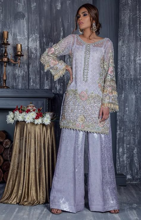 Standout in this gorgeous chiffon shirt embellished with tilla, kora dabka, sequins and pearls. It is further enhanced with floral thread embroidery. Its hemline and sleeves are beautifully decorated with golden tassels. It is beautifully coordinated with self embroidered jacquard bell bottom trousers. Party Dress Pakistani, Grey Party Dress, Asian Fits, Floral Thread Embroidery, Raw Silk Pants, Asian Attire, Iron Clothes, Dress Pakistani, Pakistani Wedding Outfits