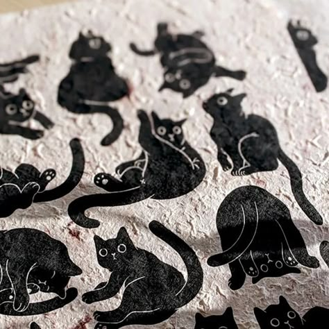 Booba Prints Illustrator & Linocut Printmaker on Instagram: "12 cats! 🐈🐈 Here are pictures of this new print of mine 😊 The other day I had a glimps of sunlight in my apartment, so I had to take a few pictures 🌞 Even though it was harder to print on such textured paper, I'm really happy with how it turned out! Plus I had to do a version on my beloved natural paper 💃🏻 #printmaking #justprintmaking #popmembers #peopleofprint #reliefprint #linocutfriends #printmakersofinstagram #printersofinstagram #boobaprints #boobaprints #linocur #linoprints #linocutprint #linoleumblockprint #printsforyourwalls #traditionalprintmaking #womanillustrator #womenprintmakers #get_imprinted #catprints #blackcatart #blockprinted #printmaker #printmakingcommunity #printmakingprocess" Black Cats Illustration, Black Cat Linocut, Cat Block Print, Cat Printmaking, Cat Lino Print, Cat Linocut, Linoleum Printmaking, Print Making Designs, Black Cat Illustration