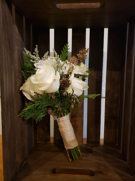 White Rose Pine Cone Bouquet, Evergreen Bridesmaid Bouquet, Bridal Bouquet Winter Simple, Pine Cone Bridal Bouquet, January Wedding Bouquet Winter Flowers, Winter Wedding Flowers Bridesmaid, White Roses And Pine Cones, Wedding Bouquet With Pinecones, Bridesmaid Bouquet Winter Wedding