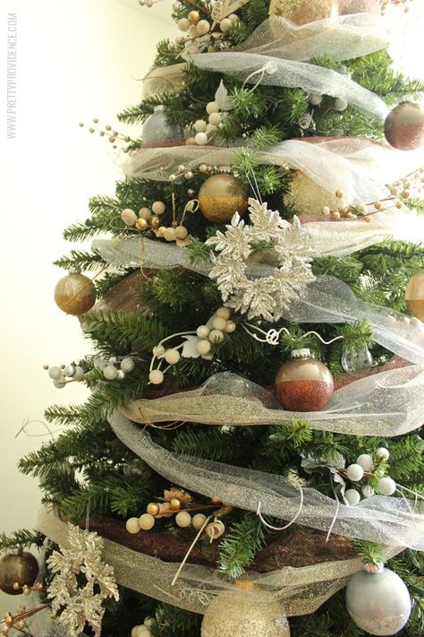 I am in love with this whimsical precious metals Christmas tree! Doesn't it just make you want to curl up with a blanket and watch lights dance for hours? Click through for how to's and more images! Christmas Tree With Tulle Garland, Tulle In Christmas Tree, Christmas Tulle Decorations, Christmas Minimalist Decor, Neighbor Gifts For Christmas, Christmas Tree Dyi, Christmas Tree Ribbon Garland, Tulle Garland, Tulle Christmas Trees