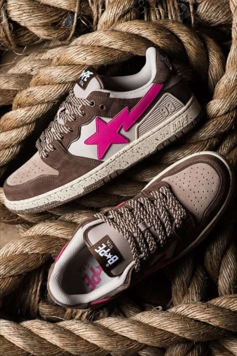 As its name implies, BAPE’s SK8 STA is heavily inspired by skateboarding culture and its design owes to some of the most popular skate silhouettes on the market. In addition to the leather overlays, the sides are adorned with A BATHING APE’s signature STA logo. These sneakers arrives in unique mix of brown and tan shades, offset by the bright pink STA logo.⁠ Bape Sneakers Outfit, Bape Sk8 Sta, Tan Shades, Sk8 Sta, Bape Sneakers, Bape Shoes, Shoes Names, Pretty Sneakers, Style Harem Pants