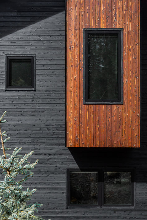 A medium shot of the front facade of the Grand Ridge House. Two different finishes of yakisugi siding, Gendai® Alkyd Black and Pika-Pika® Linseed Brown, are being bathed in sunlight, showing off the wood detail and striking contrast between the two surfaces. The Pika-Pika siding is clad on an outcropping, accentuated by the geometric design of the house. Yakisugi Houses, External Cladding, Rustic Office, Sugi Ban, Architectural Design House Plans, Shou Sugi Ban, Tung Oil, Wood Siding, Exterior Siding