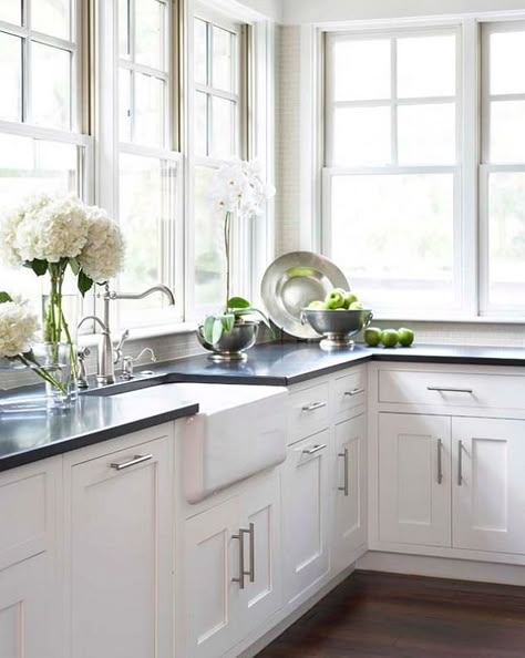 Kitchen:  white shaker cabinets, absolute black granite counters, white farmhouse sink, lots of windows, and flowers. No Upper Cabinets, White Farmhouse Sink, Kabinet Dapur, Black Countertops, Southern House, Staging Ideas, Kitchen White, White Sink, Upper Cabinets