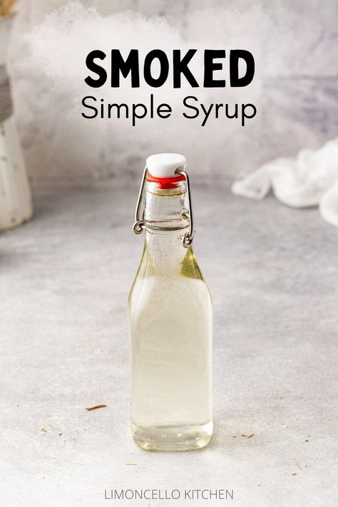 Smoked simple syrup in a swing-top bottle on a gray countertop. Text above the bottle reads "Smoked Simple Syrup" with a light smoke pattern behind it. Recipes Coffee Drinks, Smoked Simple Syrup, Drinks Lemonade, Bourbon Old Fashioned, Simple Syrup Cocktails, Simple Syrups, Smoked Cocktails, Drink Syrups, Homemade Soda