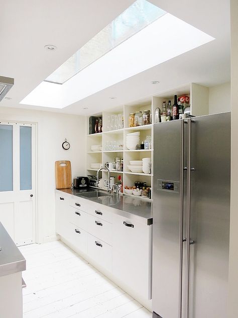 stainless countertops  Narrow kitchen looks a lot more spacious thanks to the skylight - Decoist Kitchen Skylights, Windows In Kitchen, Vaulted Ceiling Decor, Kitchen Skylight, Modern Skylights, Steel Countertops, Attic Kitchen, Vaulted Ceiling Kitchen, Full Kitchen Remodel