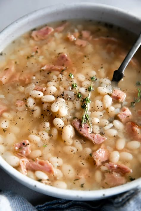 This Navy Bean Soup with Ham is a simple, hearty, and flavorful bean soup recipe filled with leftover ham and tender cooked navy beans. Perfect for lunch or dinner with a side of buttery bread. Ham Navy Bean Soup Crockpot, Ham And Navy Bean Soup Recipes, Senate Navy Bean Soup Recipe, Creamy Navy Bean Soup, Navy Bean Soup With Ham Crockpot, Ham N Bean Soup, Senate Bean Soup Recipe, Ham And Beans With Ham Bone, Mayo Coba Beans Recipes