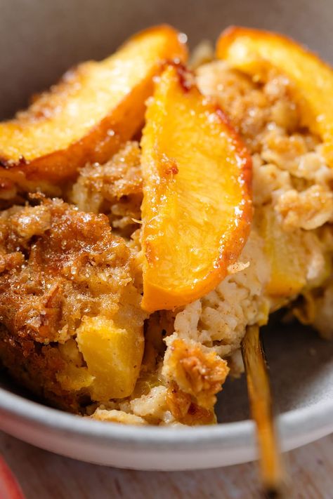 This Baked Peach Oatmeal is packed with flavor and really easy to make. The oatmeal is light and packed with chopped peaches on the inside and crispy and toasty on the top. It gets topped with more peach slices that caramelize with sugar in the oven and take it from great to amazing. Serve with yogurt, berries, or more peaches for breakfast or brunch. Peach Cobbler Yogurt Bowl, Breakfast Peach Recipes, Peach Breakfast Ideas, Peaches For Breakfast, Peach Breakfast Recipes Healthy, Peach Breakfast Recipes, Peach Oats, Peach Recipes Breakfast, Peach Baked Oatmeal