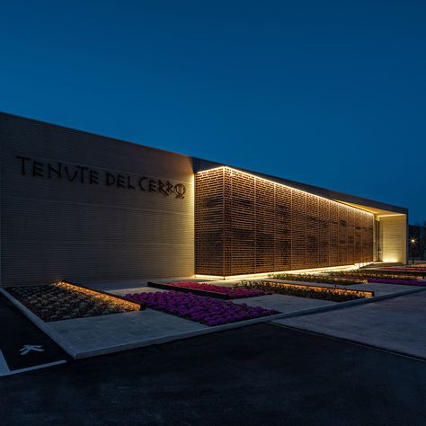 Architectural lighting by Targetti for the Le Cerraie winery in the Tuscan hills, Italy. Le Cerraie winery designed by b-sign Architects has a total area of 4000 square meters. The façade of the building is characterized by a wooden brise-soleil designed for evoking the paths of the vineyards. . lighting effect / grazing lighting / lighting design Nightclub Design Exterior, Nightclub Exterior Design, Winery Lighting, Reference Lighting, Winery Signage Entrance, Wine Architecture, Winery Building Architecture, Wineries Architecture, Tuscan Hills