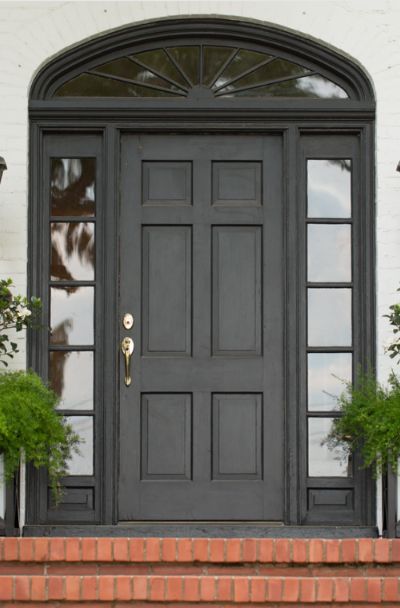 31 Houses With Black Front Entry Door Ideas | Sebring Design Build Black Front Door Entrance, Black Metal Entry Door, Black Front Doors Exterior, Arched Front Door Entryway, Black Front Door Ideas, Entry Door Ideas, Black Entry Door, Rustic Front Door Decor, Stained Front Door