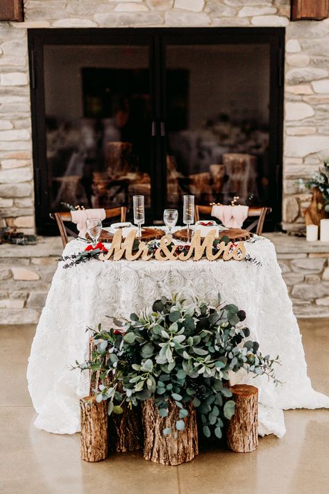 Wood stump arrangement with greenery in front of head table, gold Mr. and Mrs. signs, ivory rosette tablecloth, fireplace head table  Venue: The Sycamore Winery Photography: Kayla Lynn Creative Floral: Cowan & Cook Food: Edibles Catering Rustic Bride And Groom Table Ideas, Front Of Head Table Decor, Wedding Party Head Table Decor, Inside Wedding Arch, Mr And Mrs Table Decoration, Me And Mrs Table, Western Sweetheart Table, Wedding Signing Table Ideas, Mr And Mrs Table Wedding