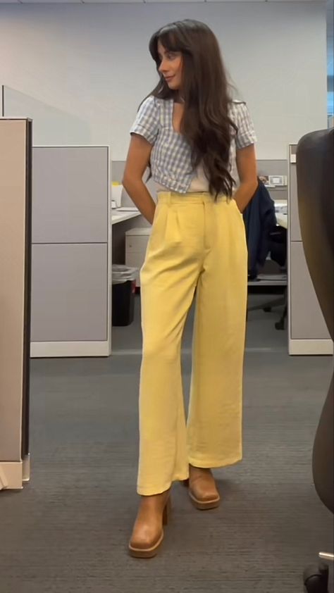 Girl with long brown hair stands in office with a blue gingham short sleeved cardigan, with a white cami underneath, yellow pants, and beige boots. Business Casual Fun Outfit, Office Cool Girl Outfit, Unique Business Casual Outfits For Women, Pink And Green Work Outfit, Formal Colorful Outfit, Pastel Corporate Outfit, In Office Outfit, Spring Corporate Outfits, Corporate Job Outfit