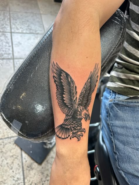 Traditional tattoo, eagle tattoo, bird tattoo, flying bird tattoo, black and grey tattoo, realism tattoo, arm tattoo, bird tattoo design Small Eagle Tattoo Men Forearm, English Tattoo For Men, Eagle Tattoo For Women Forearm, Men’s Bird Tattoo Arm, American Indian Tattoos For Men, Eagle Bicep Tattoo, Eagle Tattoo Leg, Eagle Forearm Tattoo, Traditional Eagle Forearm Tattoo