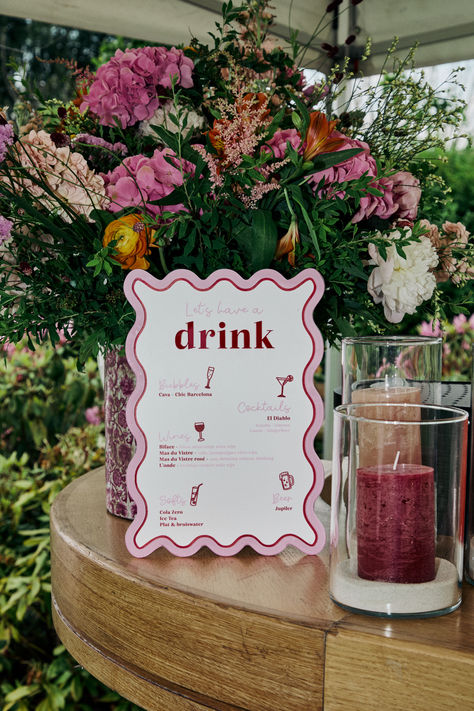 Brighten your garden wedding with this unique wavy bar sign! Hand-drawn elements in pink, white, and red add a whimsical touch to your celebration. Perfect for adding a pop of color and a personalized feel to your special day. 🌸✨ #GardenWedding #WeddingDecor #BarSign #HandDrawn #ColorfulWeddings #WhimsicalDecor #WeddingIdeas #OutdoorWedding #CustomSignage #WeddingInspiration Wedding Juice Bar Ideas, Spring Engagement Party, Red Purple Wedding, Wedding Reception Inspiration, Reception Inspiration, Spring Engagement, Custom Signage, Retro Wedding, Juice Bar