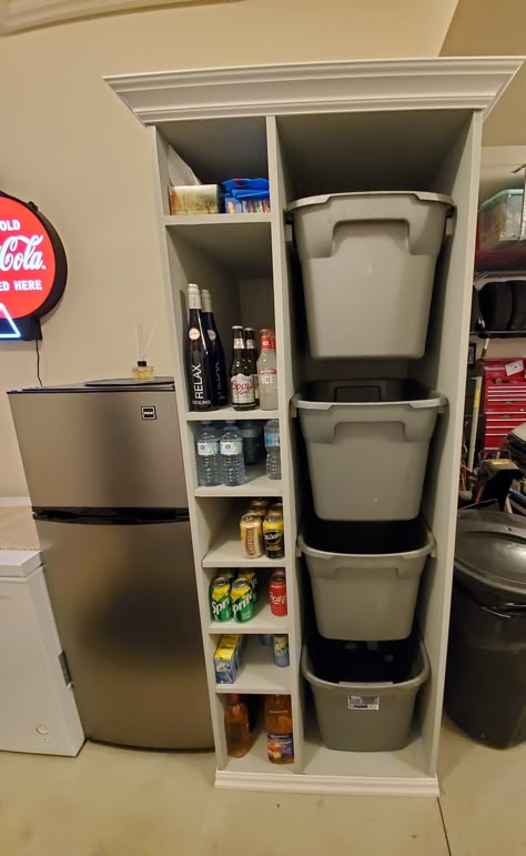 We have a recycling station that has four bins for your cans and bottle and cardboard and six shelves for pop, water or beer or wine for that garage fridge.  The unit is made of 3/4 MDF and is paintable and also has crown molding.  It is very useful and is a space saver.  The bins are taken right to curb for pick up. Fridge And Freezer In Garage, Small Space Recycling Station, Pull Out Tote Storage, Recycle Station Diy, Bottle Recycling Storage, Garage Cooler Storage, Recycling Organization Garage, Garage Drink Storage, Garage Fridge Organization