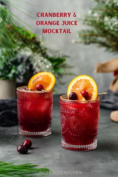 two red colored mocktails with orange and cranberry garnish Mocktail With Orgeat, Fall Wedding Drinks Non Alcoholic, Fall Drinks Mocktail, Thanksgiving Non Alcoholic Drink, Best Mocktails Fall, Thanksgiving Drinks Non Alcoholic For A Crowd, Maple Syrup Mocktail, Breakfast Beverages Non Alcoholic, Orange Juice And Cranberry Juice Drinks