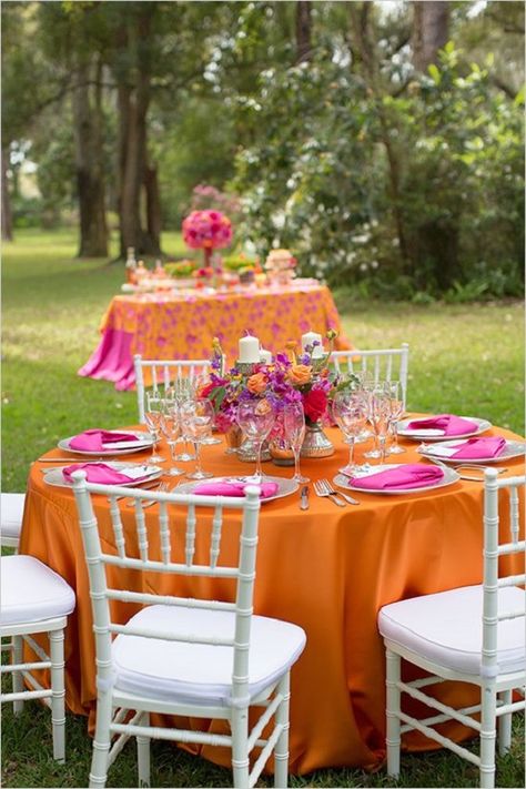 Hot pink and orange for october wedding colors 2025, mismatched hot pink and orange bridesmaid dresses, white bridal gown, hot pink and orange flower of bouquets, ceremony arch and centerpieces, white wedding cake with hot pink and orange flower décor,  orange wedding tablecloth and hot pink wedding napkins. Pink And Orange Bridesmaid Dresses, Pink Wedding Napkins, Wedding Colors 2025, Bold Shoot, October Wedding Colors, Bridesmaid Dresses White, Colors 2025, Bridal Proposal, Colorful Centerpieces