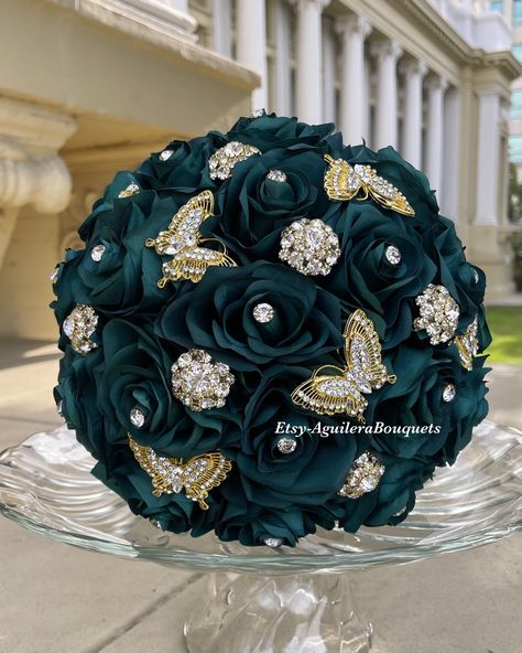 This bouquet is handmade with emerald green roses and gold brooches and butterflies. The design can be changed if requested. I can do it in different colors. Please message me the color.  *This bouquet is 10 inches in diameter* Please contact me with any questions! :) Emerald Green Quince Accessories, Emerald Green Quinceanera Bouquet, Emerald Green Quince Flowers, Emerald Green And Gold Quince Bouquet, Emerald Green Ramos, Emerald Green Dama Dresses For Quince, Chambelanes Outfits Quinceanera Emerald Green And Gold, Emerald Green Quince Damas Dress, Emerald Green Quince Dress With Butterflies