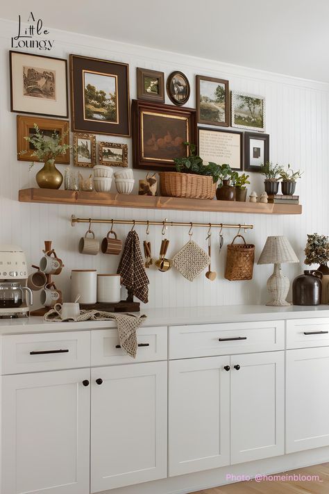 vintage-inspired art is the showcase of this stunning coffee bar! And, a metal hanging rack is always a great addition to a counter coffee bar for essentials like mugs, spoons, and dish towels. Vintage Decor Above Kitchen Cabinets, Coffee Bar Hanging Mugs, Kitchen Buffet Table Ideas Decor, Kitchen Wall Display Ideas, Kitchen Wall Styling, Floating Wood Kitchen Shelves, Shelving Above Buffet, Hanging Mugs Under Cabinet, Stove Top Decor Ideas