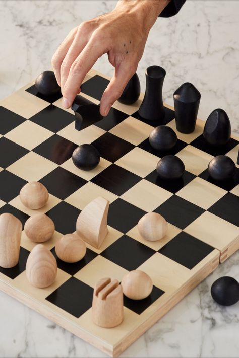 Foldable wooden chess set designed by Panisa Khunprasert. This chess set features minimalist turned-wood chess pieces that evoke modern sculptures. Subtle details are employed to identify the various pieces: a diagonal slice on the oval-shaped Bishop suggests a liturgical headpiece; two deep grooves create castle turrets for the cylindrical Rook; the Knight’s arched lines follow the shape of a horse’s head. Flat Chess Pieces, How To Make Chess Pieces, Clay Chess Set, Clay Chess, Chess Board Design, Diy Chess Set, Modern Chess Set, Chess Design, Knight Chess