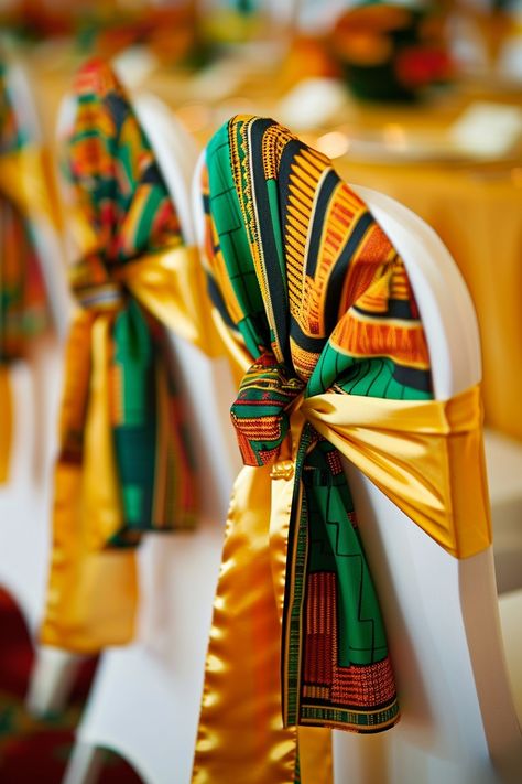 Transform your wedding venue into a cultural haven with vibrant Kente cloth chair sashes. Perfect for an Afrocentric celebration, these sashes add a touch of heritage and style. 🌍💒🎉 Celebrate love with a traditional twist! #WeddingInspiration #AfricanWedding #KenteDesign #WeddingDecor #AfrocentricWedding #CulturalElegance #ChairSashes #WeddingDetails African Weddings Decoration, Coming To America Wedding Theme, Ghana Wedding Decorations, South African Wedding Decor, African Wedding Theme Decoration, Traditional Lobola Decor, African Traditional Wedding Decoration, Africa Theme Party, African Theme Party