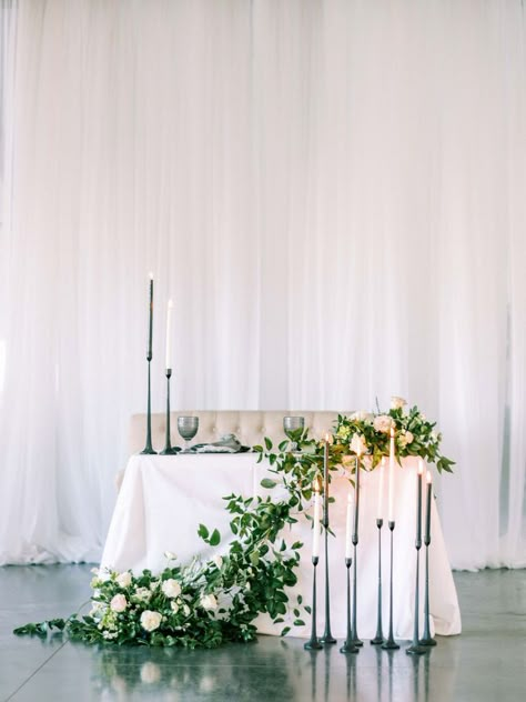 The sweetest sweetheart setup. Black and white candles and the table draped with fresh greens and creams flowers is the perfect neutral tablescape for your modern wedding. Black And White Candles, Neutral Tablescape, Green And White Wedding Flowers, Sweetheart Table Flowers, Top Table Flowers, Wedding Top Table, Wedding Head Table, Sweetheart Table Decor, Head Table Wedding