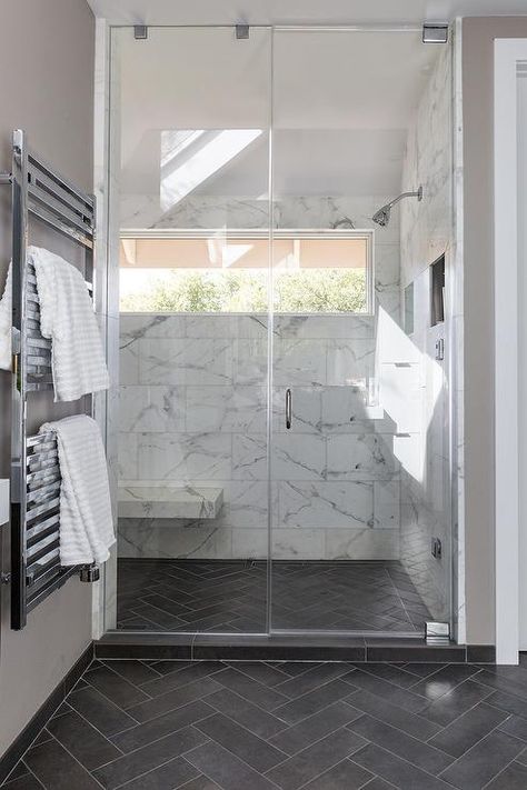 Slate herringbone pattern floor tiles in a transitional bathroom includes a seamless glass shower with large white and gray marble staggered wall tiles. Floor Herringbone Pattern, Floor Herringbone, Pattern Floor Tiles, Dark Tile Floors, Grey Bathroom Floor, Slate Bathroom, Design Interior Baie, Dark Gray Bathroom, Bathroom Dark