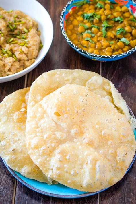 Poori on a blue plate served with chana masala and suji ka halwa Food Pakistani, Halwa Puri, Desi Breakfast, Pakistani Foods, Masala Chai Recipe, Poori Recipe, Pakistani Desserts, Pakistani Cooking, Carnival Conquest