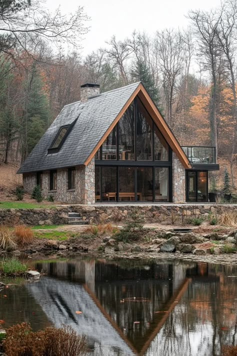 Stone cabin reflecting in a tranquil pond, embraced by trees. From rustic mountain retreats to urban lofts with views worth a million bucks (or maybe we’re just out of breath from the altitude), Colorado homes have their very own kind of charm. Steep Roof Pitch Home, Wood House Design Exterior, A Frame Cabin Design, Small Mountain Home Exterior, A Frame Mountain Home, Colorado Cabin Aesthetic, Mountain Aesthetic Home, Double A Frame House, Modern Chalet Architecture