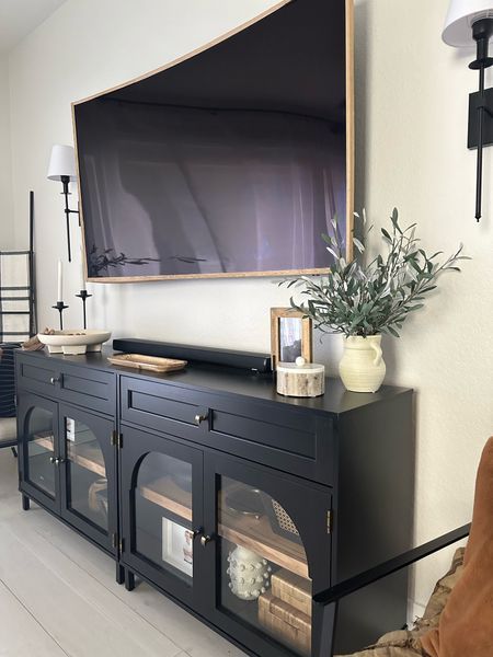 Below The Tv Decor, Black Sideboard Living Room Tv, Black Tv Stands Living Room, Tv Stand Decor Under Mounted Tv, Glass Tv Stand Styling, Entertainment Decor Ideas, Wall Decor By Tv On Wall, Entertainment Center Wall Decor, Tv Stand Ideas Apartment