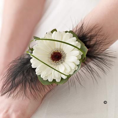 White Germini & Feather Wrist Corsage  We’ve chosen a stunning white germini as the centrepiece for this modern wrist corsage. Delicate black feathers, rich green leaves and fine strands of bear grass are carefully added to create a truly beautiful adornment. Modern Wrist Corsage, Corsage With Feathers, Wrist Corsage Ideas, Hand Corsage, Wristlet Corsage, Prom Flowers Corsage, Wedding Wrist Corsage, White Gerbera, Homecoming Flowers