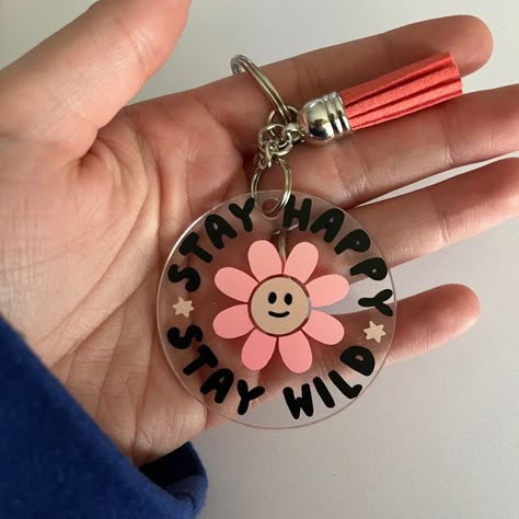 2-inch motivational acrylic keychain, keychain accessories, permanent vinyl acrylic keychain This is a ready-to-ship, 2-inch acrylic keychain with the words "Stay Happy Stay Wild" in black vinyl, the center of a flower in light pink vinyl, and the petals of the flower in a pink/orange colored vinyl that looks different in different lighting Clear Keychain Ideas, Circle Acrylic Keychain Ideas, Circle Keychain Ideas, Cricut Keychains Diy Acrylic, Cricut Keychain Ideas, Acrylic Keychain Ideas, Keychain Vinyl, Vinyl Acrylic, Cricut Projects Easy