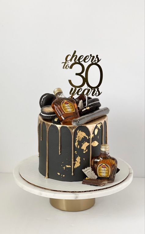 Black cake with gold drip and gold leaf details. On top and on the side there are assorted chocolates and crown royal bottles. There’s a cigar on top of the cake as well as a cake topper that reads “Cheers to 30 years”. Cake For Him Birthday, Man 30th Birthday Ideas, 30th Birthday Party For Him, Cake Black And Gold, Dirty Thirty Cake, Dirty 30 Cake, 30th Birthday Cakes For Men, Black And Gold Birthday Cake, 35th Birthday Cakes