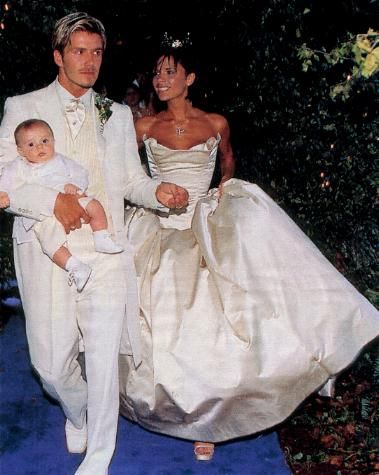 July 4, 1999: David and Victoria Beckham were already big stars when they wed at 16th Century Luttrellstown Castle near Dublin. Victoria wore Vera Wang, Becks wore ivory and cream for the ceremony, but changed into purple for the reception after the couple's infant son Brooklyn threw up on him. Footballer Gary Neville served as best man, and all four Spice Girls were in attendance. An 18pc. orchestra entertained a black-and-white reception, and the couple donated their 5-tier cake to charity. Victoria Beckham Wedding Dress, Victoria Beckham Wedding, Beckham Wedding, Victoria And David Beckham, Famous Brides, Celebrity Wedding Photos, Celebrity Brides, 16th Wedding Anniversary, Posh And Becks