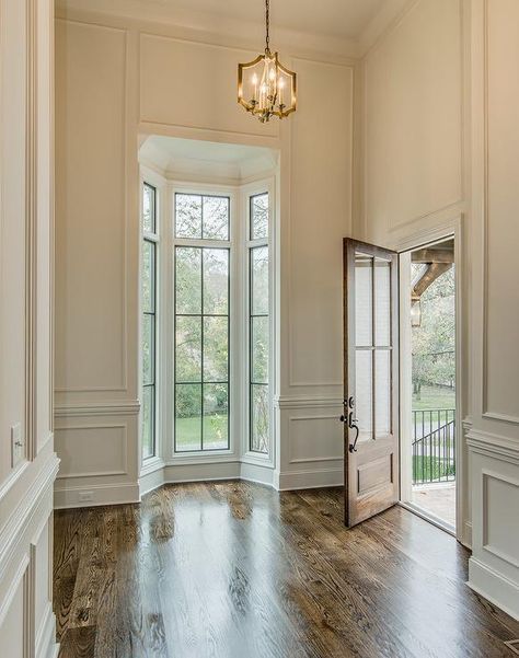 Chic foyer features tall ceilings over full wall wainscoting framing a small bay window | Vintage South Development Colour Hallway, Entrance Modern, Modern Hallway, Tall Ceilings, Empty Room, Narrow Hallway, Hallway Ideas, House Goals, Wainscoting