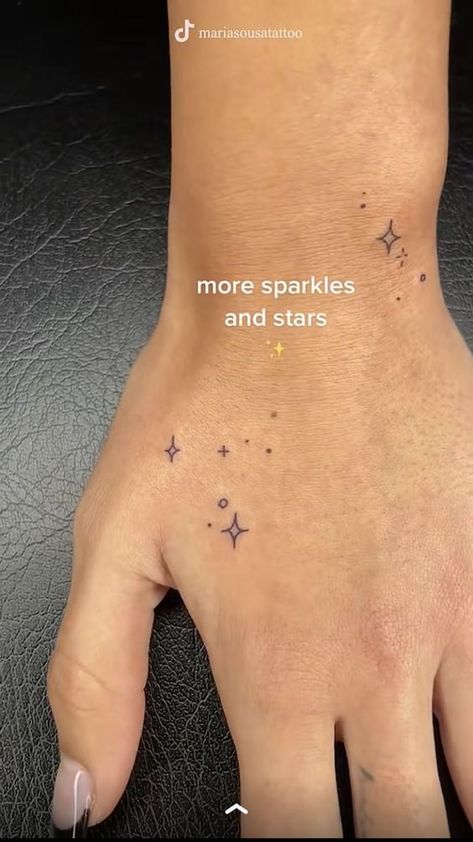 Sparkle Tattoos On Hand, Tiny Star Hand Tattoo, Micro Arm Tattoo, Fairy Dust Tattoo Stars, Ken Eurich Hand Tattoos, Sparkling Tattoo Ideas, Galinda Tattoos, Hand Sparkles Tattoo, Earring Tattoos For Women