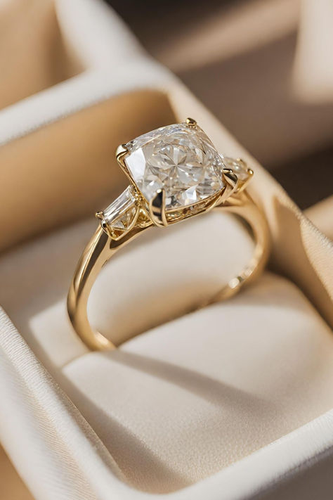 Ranked 10th among our collection of 15 Cushion Cut Diamond Engagement Rings, the Vintage Cushion Cut Diamond Ring with Baguette Side Stones in Yellow Gold showcases a harmonious blend of classic charm and modern sophistication. Click below to discover more captivating designs. Cushion Engagement Ring Vintage, Engagement Rings Design Gold, Vintage Inspired Moissanite Engagement Rings, Gold Engagement Ring With Side Stones, Gold Ring Marriage, Bevel Setting Engagement Ring, Unique Cushion Engagement Ring, Cushion Cut Engagement Ring With Thick Band, Simple 3 Stone Engagement Rings