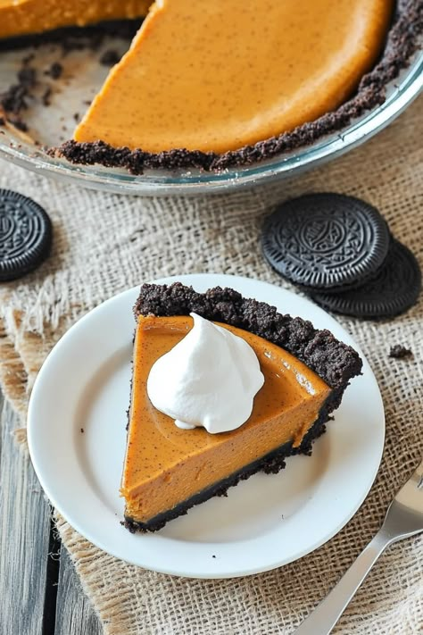 Indulge in a delightful fall treat with this irresistible pumpkin pie with Oreo crust recipe. The combination of smooth, spiced pumpkin filling and crunchy chocolate cookie crust is sure to be a hit at your next gathering. This dessert is easy to make and perfect for autumn celebrations or holiday dinners. Treat yourself and your loved ones to a slice of this decadent pie – you won't be disappointed! Pumpkin Pie Chocolate Crust, Pumpkin Pie With Oreo Crust, Pumpkin Pie Oreo Crust, Oreo Pumpkin Pie, Pumpkin Pie With Chocolate Crust, Pumpkin Chocolate Pie, Pie With Oreo Crust, Oreo Crust Recipe, Cookie Dough Crust