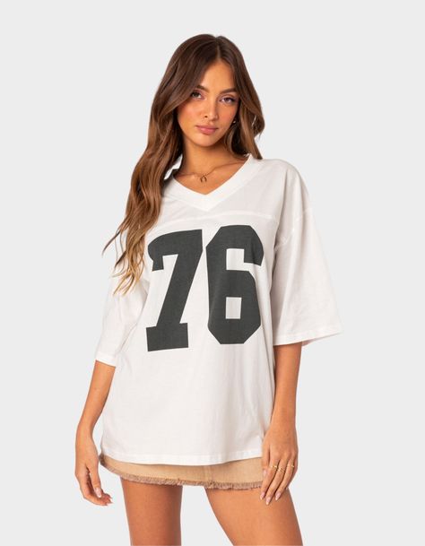 The Perfect Combination Of Comfy And Cool, This Oversized V-Neck Tee Will Have You Looking Sporty And Chic Wherever You Go. T-Shirt. Oversized Fit. Graphic Text. V-Neck. 100% Cotton. Model Wears Size S. Model Height Is 5'9. Item Care: Wash With Similar Color. | Edikted 76 Oversized Tee Oversized Jersey, Flannel Sweatshirt, Retro Jersey, Low Rise Jeans, Sweaters And Jeans, Oversized T Shirt, Women Trends, Top Fabric, Jersey Top