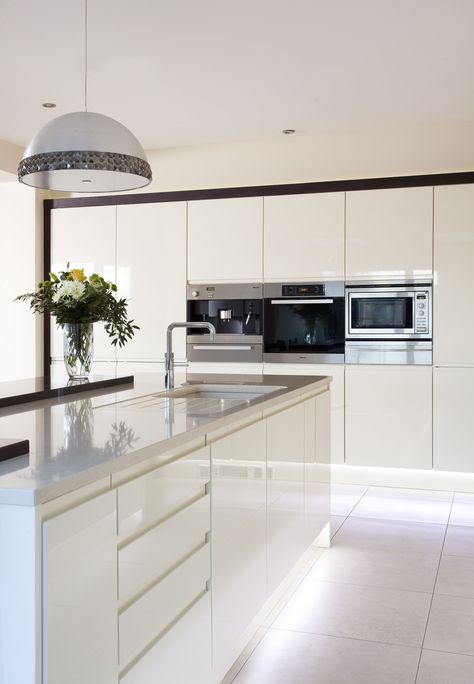 Sleek lines with this white gloss handleless kitchen and Silestone worktops. Gloss White Kitchen Island, Modern White Gloss Kitchen, White Kitchen Worktop Ideas, White Kitchen White Appliances, Gloss Kitchen Cupboards, White Kitchen Diner, White Handless Kitchen, White Gloss Kitchen Ideas, White Open Plan Kitchen