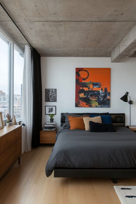 Modern bedroom with a dark gray bed, colorful abstract art, and large window. Minimal Male Bedroom, Men’s Bedroom Minimalist, Men’s Cozy Bedroom, Men’s Minimalist Apartment, Interior Design Mens Bedroom, Minimal Men Bedroom, Apartment Bedroom Minimal, Guy Apartment Bedroom, Minimal Mens Apartment