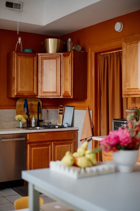 Rust painted wall in kitchen with wooden cabinets. Kitchen With Orange Wood Cabinets, Orange Wood Cabinets, Orange Cabinets Kitchen, Orange Kitchen Cabinets, Orange Kitchen Walls, Rust Kitchen, Coral Kitchen, Orange Cabinets, Hickory Kitchen Cabinets