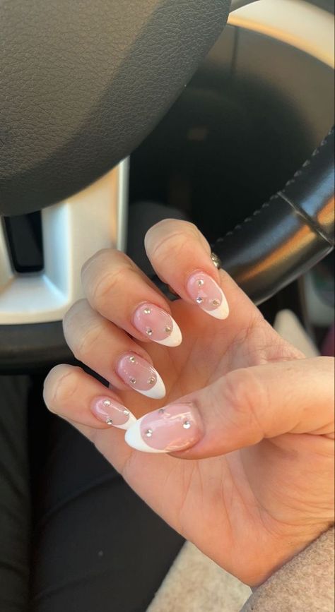 White French Tip Nails Almond With Silver Line, Oval French Nails With Rhinestones, Oval French Tip With Design, White French Tip With Glitter Almond, French Tip Almond Nails With Jewels, Short Almond Nails Designs With Gems, White And Silver Nails Almond Shape, Hoco Nails White And Silver, White French Tip With Gems Almond