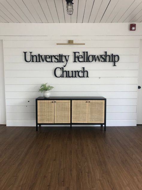 This church has a new brand wall in the entryway of their small event space. Black metal lettering, a library light and storage in their console table make this entryway inviting and functional! Church Entryway Decor Foyers, Church Lobby Design Foyers, Small Church Foyer, Church Entrance Decor, Church Entryway Decor, Church Foyer Ideas Lobbies, Church Foyer Decor, Small Event Space, Church Foyer Ideas