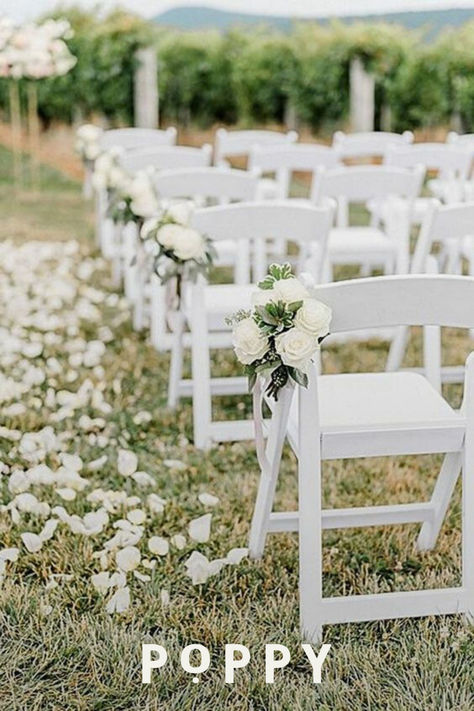 All-white wedding florals and stems give a minimalist wedding aesthetic with classic white flower bouquets and wedding aisle decor like free-falling flower petals. This classic wedding decor inspiration will delight your guests and leave happy memories for all. Wedding planning can be done on a budget with classic flower inspiration to create an ultra-romantic wedding theme for intimate micro-weddings and large weddings alike. White Rose Chair Decor Wedding, White Roses Ceremony Aisle, Flowers On Aisle Chairs, White Wedding Chair Decorations, White Wedding Flowers Isle, White Roses Down Isle, Minimalist Wedding Ceremony Outdoor, Wedding Ceremony Outdoor Decorations, White Wedding Chairs Ceremony