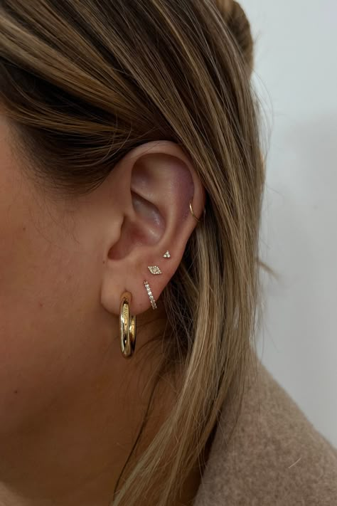 Have fun creating an ear stack you'll love. From solid gold hoops, diamond huggies and studs these earrings are designed to wear daily. Ear Candy Gold, Small Ear Stack, Simple Ear Stack, Eating Stack, Earring Ideas For 3 Holes, Earring Arrangement, Ear Stacking Ideas, Minimalist Ear Piercings, Earring Stacks