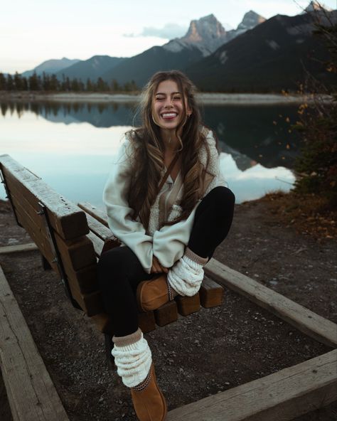 The best fall outfit ideas are the ones that are comfy, cozy, and cute! Here I’m wearing a neutral toned outfit, with a chestnut ugg tasmans, cream sherpa jacket, leg warmers, leggings, and long socks, in front of a mountain lake in Canmore!

Smile, photo inspiration, granola, girl, autumn, modest, curly long hair, layered hair, winter poses, pose ideas, bench, sitting, one leg up, tongue out, 202, 2024, eyes closed, reflection, natural makeup, casual date outfit three sisters Ugg And Leg Warmers Outfit, Mountain Date Outfit, Cabin Socks Outfit, Comfy Mountain Outfit, Winter Mountain Outfits For Women, Lake Outfit Winter, Leg Warmers With Leggings Outfit, Nature Tone Outfits, Leg Warmers And Uggs Outfit