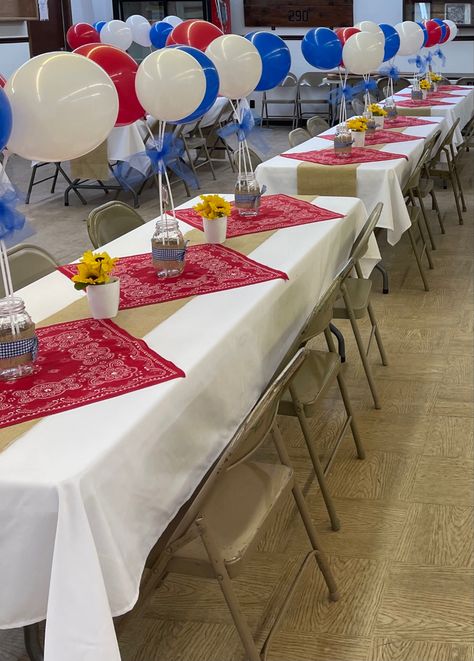 White table cloths, red bandanas, balloons on sticks tied together with blue tulle, mason jars with blue checkered ribbon, burlap table runner, sunflowers in white pots. Western Table Decorations, Balloons On Sticks, Country Graduation, Cowboy Themed Birthday Party, Western Table, White Pots, Cowboy Theme Party, Western Birthday Party, Wild West Party