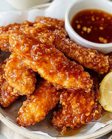 Hot Honey Chicken Tenders are the perfect balance of sweet and spicy, featuring crispy baked chicken tenders drizzled with a homemade hot honey sauce. The honey adds a delicious sweetness, ... Read more Hot Honey Tenders Recipe, Hot Honey Chicken Sauce Recipe, Jalapeno Honey Chicken, Spicy Crispy Chicken Tenders, Crispy Honey Chicken Tenders, Hot Honey Chicken Recipe Easy, Spicy Honey Sauce For Chicken, Hot Honey Crispy Chicken, Hot Honey Boneless Wings