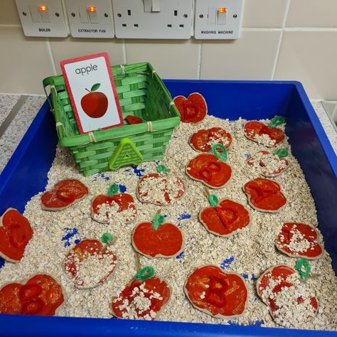 A is for Apple: The sensory bin is filled with apples emblished with letters A - D. My toddler's challenge is to only fill her basket with A's. ( This activity features ~ oats, cinnamon, A flash card, Easter basket, a wooden A, a foam A and hand crafted cardboard apples. The apple are designed with paint, pipe cleaner, hot glue and glitter. *extension* #earlyyears #nurseryteacher #toddleractivities #toddler #blackmotherhood #budgetactivity #aisforapple #appleprint #sensoryplay Oat Sensory Bin, Apple Sensory Bin, Apple Theme Sensory, Toddler Apple Activities, Apple Tree Farm, Apple Art Projects, Farm Sensory Bin, Vegetable Crafts, Sensory Activities For Preschoolers