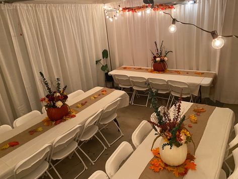 I decided to host Thanksgiving for about 15 people in my 1300 sq ft home. Being limited on space I decided to convert the garage into an extended dinning room. This setting was for 20 people. I rented the pipes and drapes, tables and chairs. It was expensive but definitely saved me time from doing it myself. It is however, totally doable on your own. With the addition of some decorations and lights it converted the space into a beautiful and elegant setting. Dinner Table Thanksgiving Decor, Thanksgiving Garage Decorations, Thanksgiving Dinner Centerpieces Diy, Thanksgiving Dinner Outfits 2023, Thanksgiving Friendsgiving Decorations, Thanksgiving Table Settings For 20 People, Thanksgiving Cafeteria Decorations, Thanksgiving Set Up Ideas, Thanksgiving Dinner Set Up Ideas